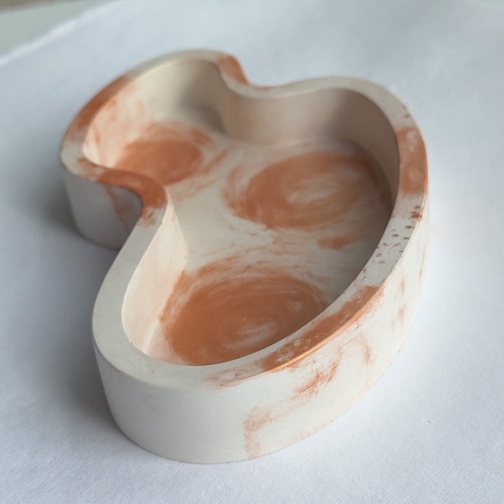 Wavy resin jewelry tray paired with matching resin decor pieces on a bedside table.