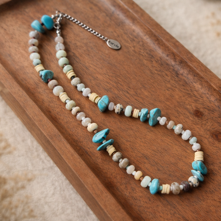 Necklace with turquoise and beige beads on a wooden tray