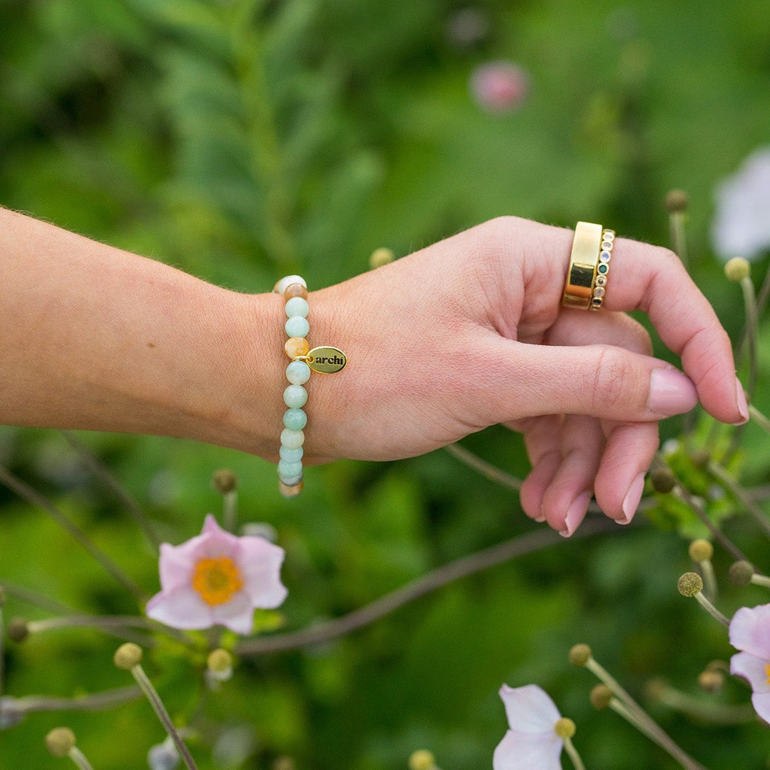 Natural stone bracelet featuring sage green Amazonite beads with brown, tan, and off-white accents.